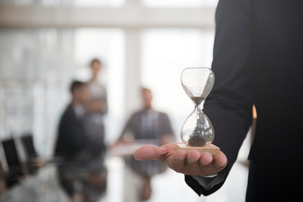 businessman holding an hour glass signifies the importance of being on time 1920x1281